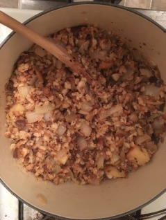 Farfel, onions, chestnuts, and apples in a Dutch oven.