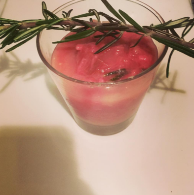 Rhubarb sauce with rosemary in a highball glass, with a sprig of rosemary perched on top