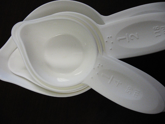 Braille measuring cups open to 1/4 cup and 1/2 cup