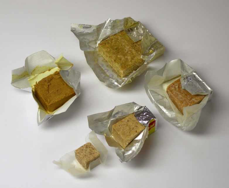 Five brown bouillon cubes in open wrappers.