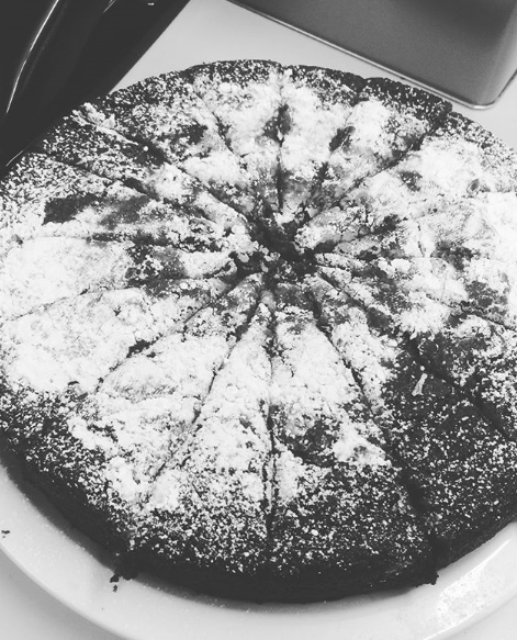 Black and white of sliced gingerbread cake covered in powdered sugar